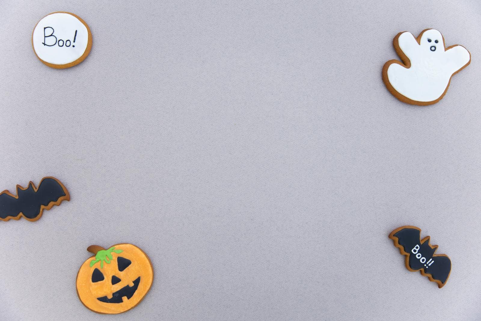 Decorated Halloween cookies including a jack-o-lantern shape on a neutral surface